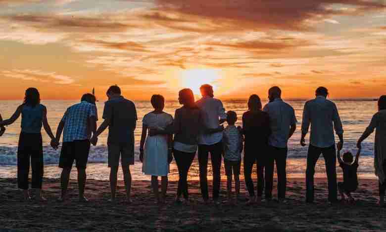 grote-familie-op-strand-zonsondergang