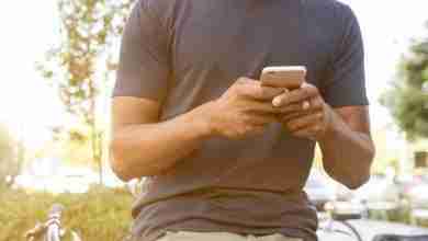 man-houdt-telefoon-vast-park