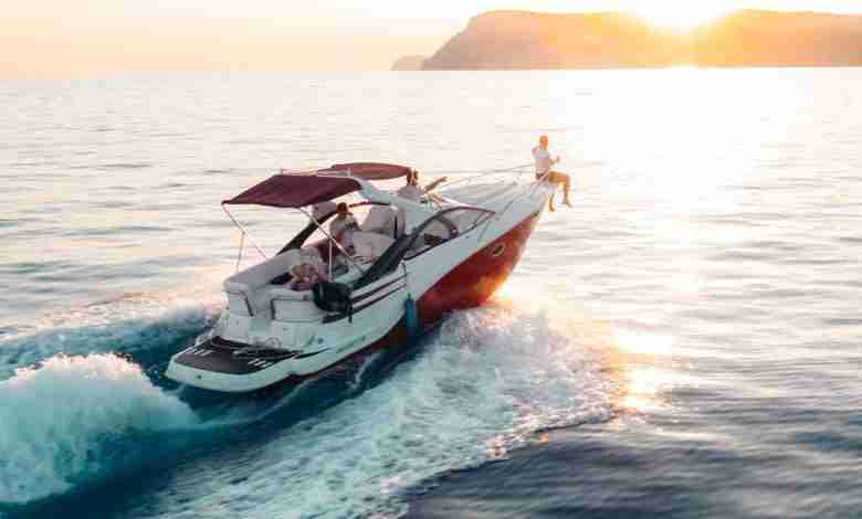 man-zit-op-voorkant-boot-zonsondergang-strand